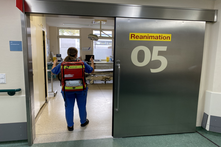 Teamomat: Weibliche Pflegefachkraft mit Rucksack vor Rea-Raum