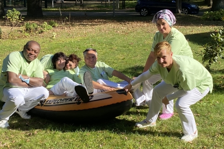 Teamomat: Sechs Menschen auf einer Wiese am und im Boot
